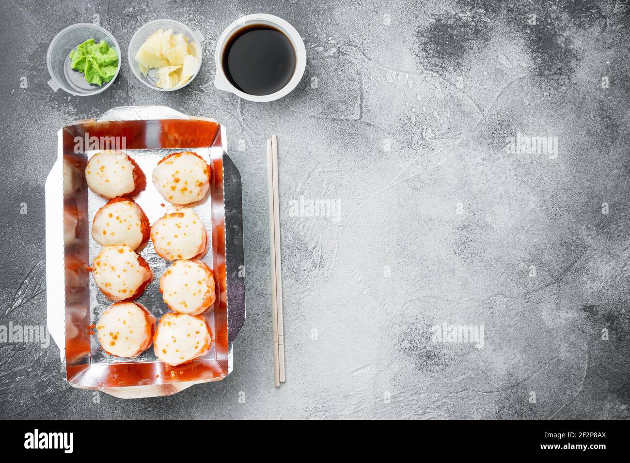 Set von Sushi-Rollen in Lieferung Food-Box-Set, auf grauem Stein Hintergrund, Draufsicht flach legen, mit Copyspace und Platz für Text Stockfoto
