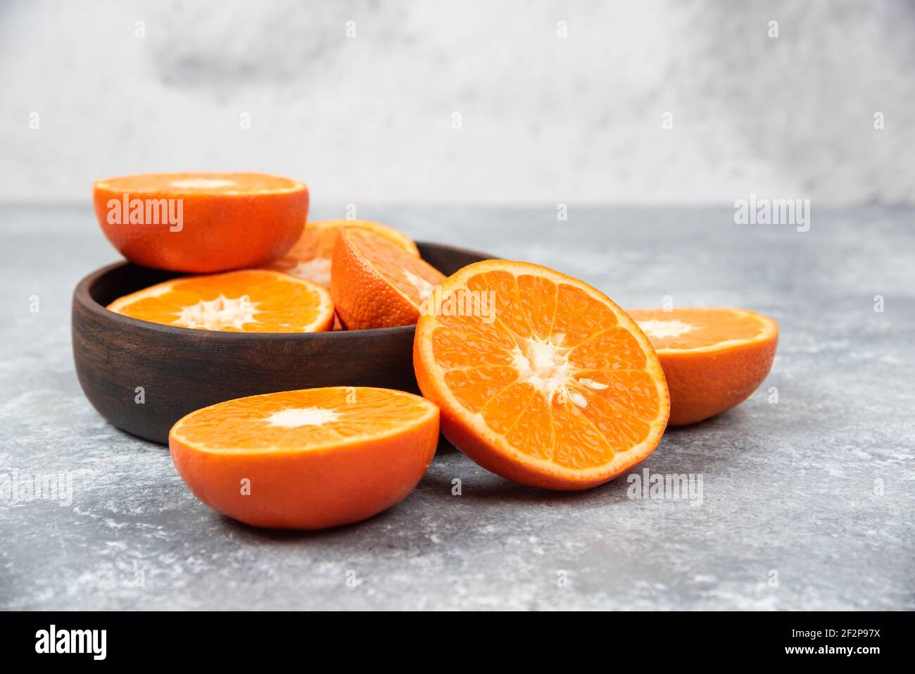 Saftige frische Orangenfrüchte in Scheiben geschnitten in einer Holzschüssel Stockfoto