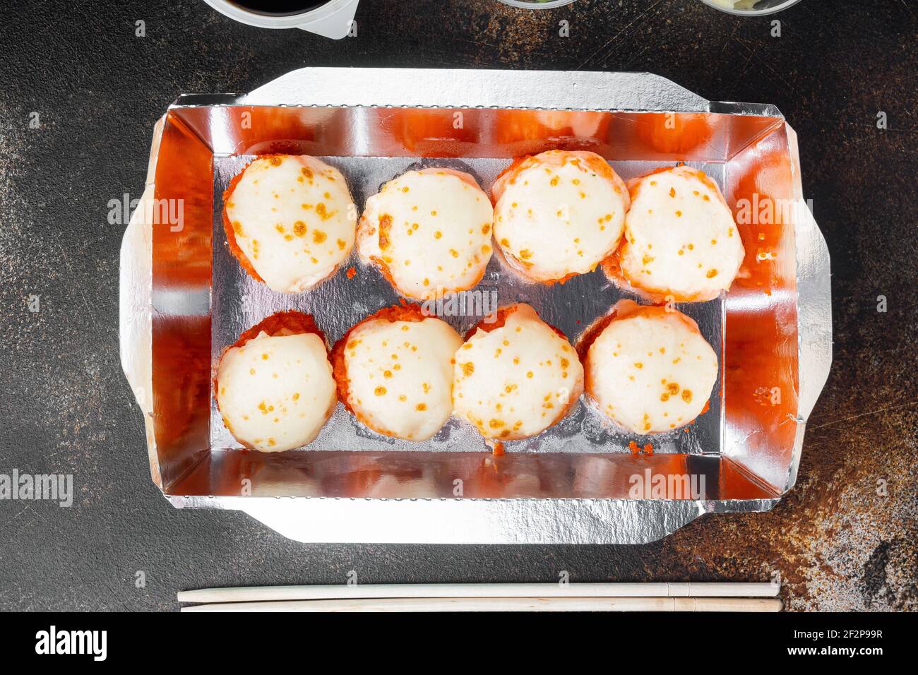 Sushi-Brötchen zum Mitnehmen in Behältern, philadelphia-Brötchen und gebackene Garnelenrollen, auf altem dunklen rustikalen Hintergrund, Draufsicht flach liegend Stockfoto