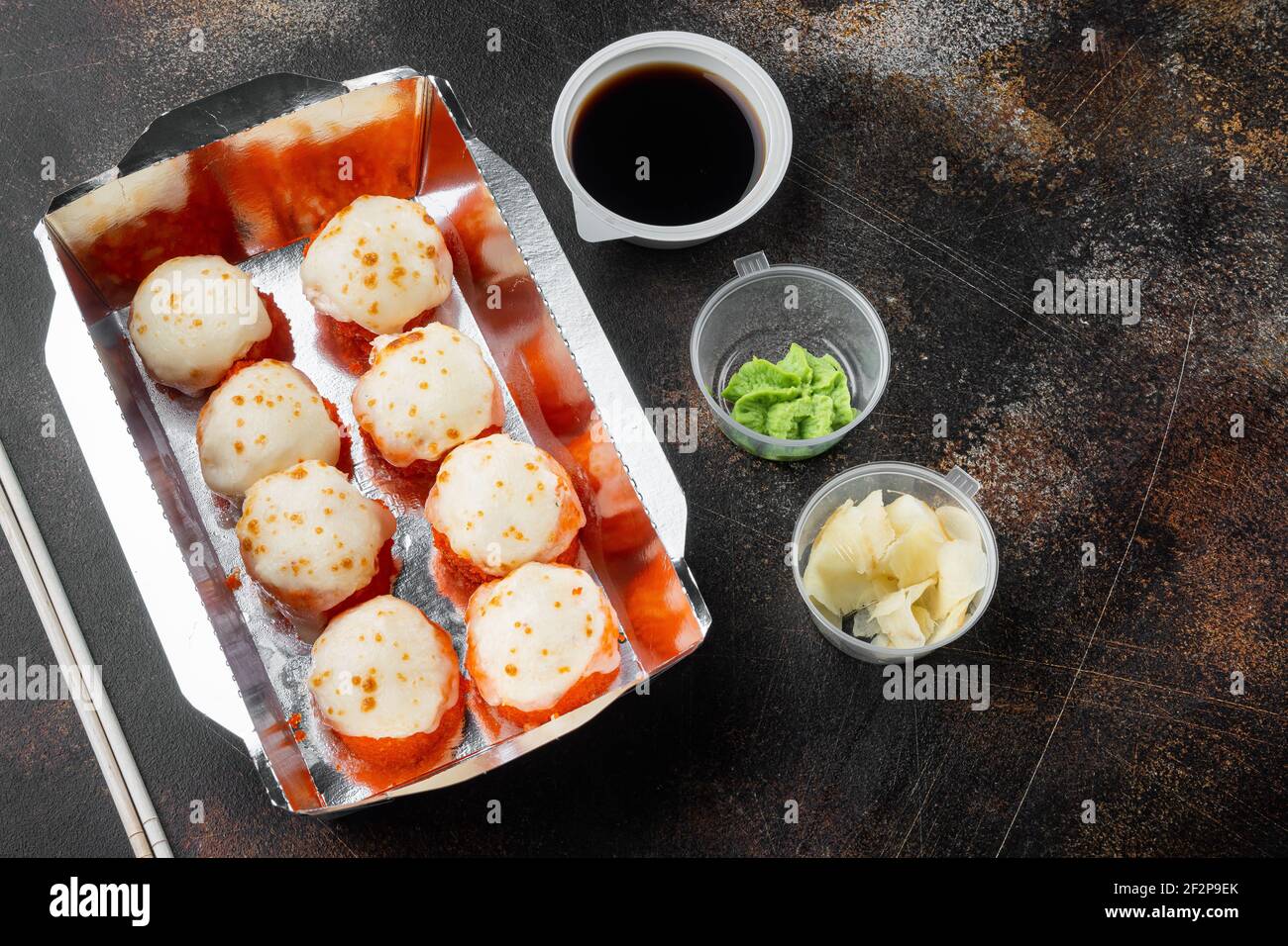 Sushi-Rollen im Takeaway-Container-Set, auf altem dunklen rustikalen Hintergrund, mit Copyspace und Platz für Text Stockfoto