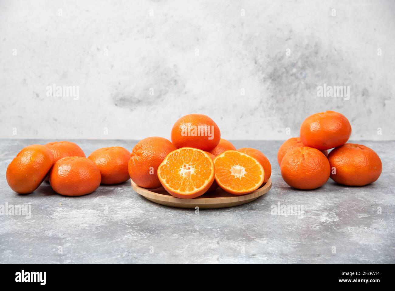 Saftige orange Früchte mit Scheiben auf Stein Hintergrund Stockfoto