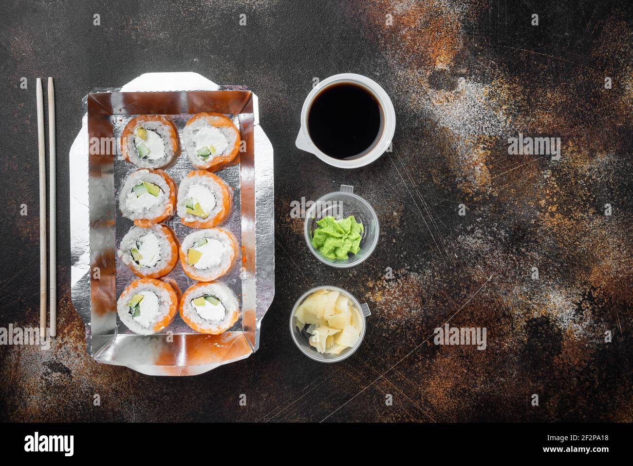 Vielfalt an verschiedenen Sushi und Brötchen fro, Lachs und Thunfisch in Lieferung Food-Konzept-Set, auf alten dunklen rustikalen Hintergrund, Draufsicht flat lay, mit copysp Stockfoto