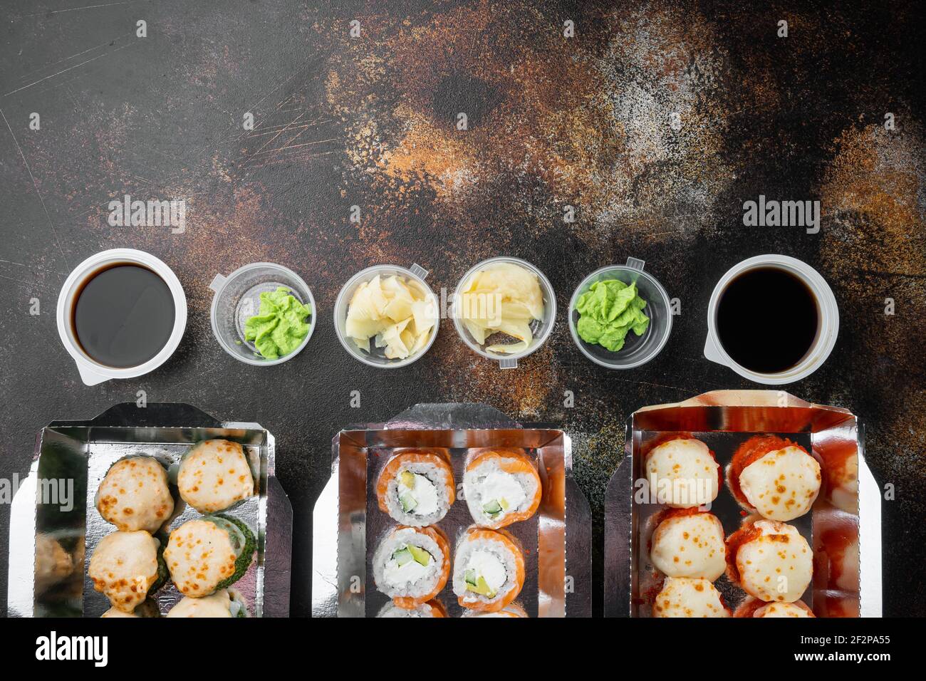 Vielfalt an verschiedenen Sushi und Rollen fro, Lachs und Thunfisch in Lieferung Food-Konzept-Set, auf alten dunklen rustikalen Hintergrund, mit Copyspace und Platz für t Stockfoto