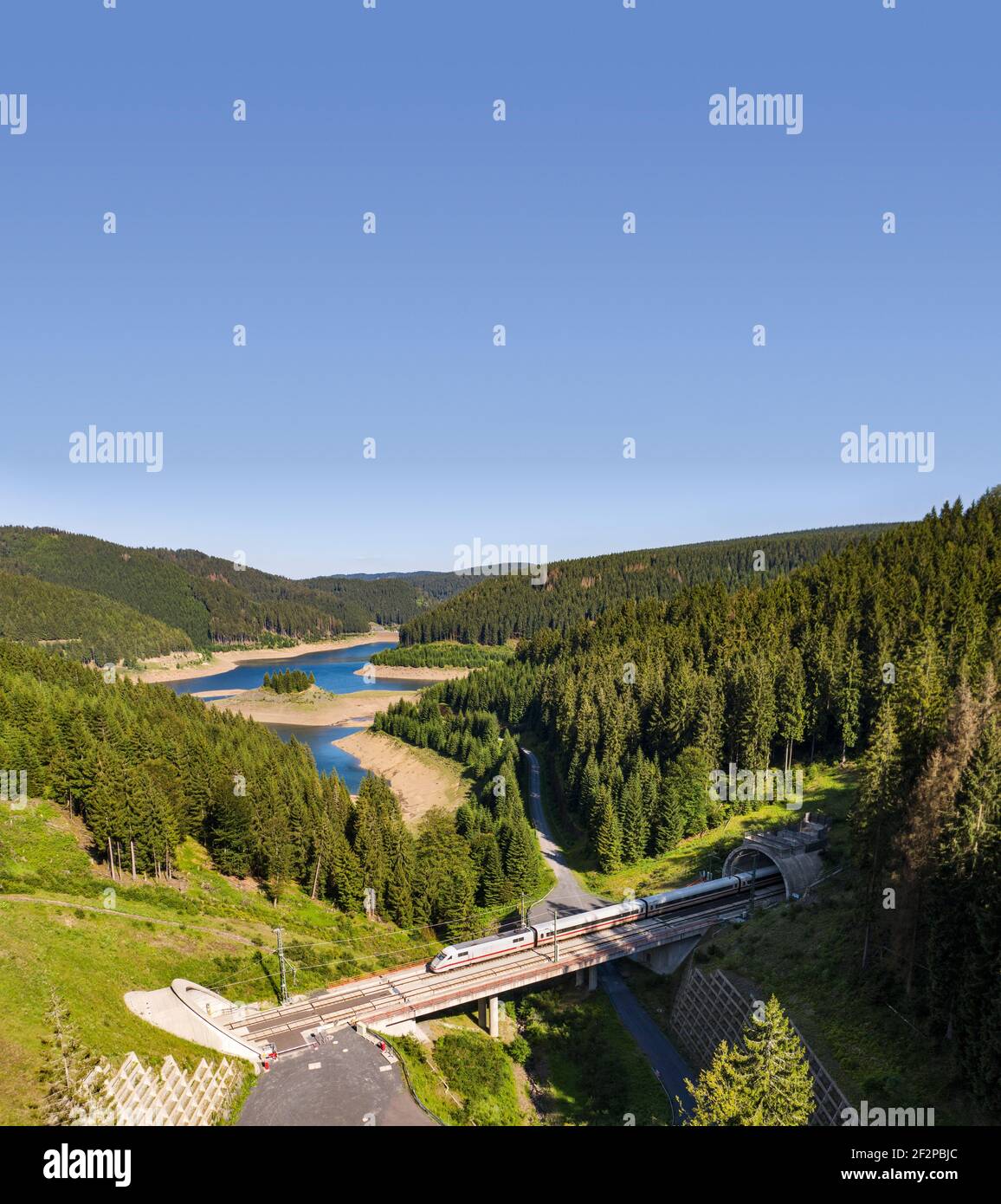 EIS fährt über eine Brücke von Tunnel zu Tunnel, überquert ein sehr schmales Tal, Wald, Berge, See Stockfoto