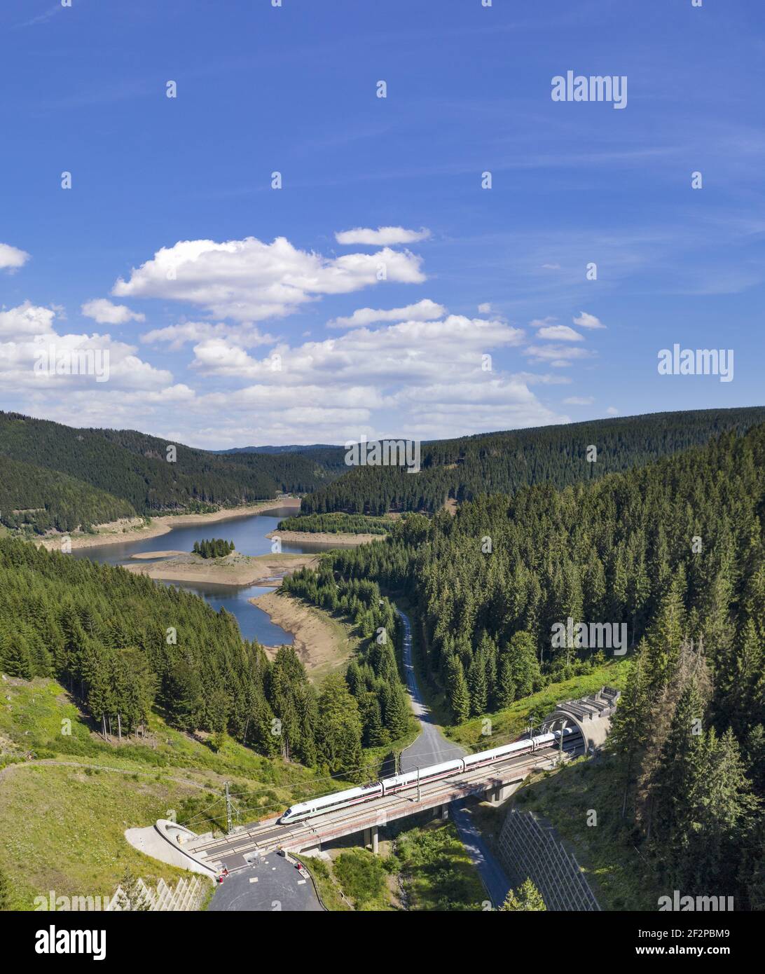EIS fährt über eine Brücke von Tunnel zu Tunnel durch ein sehr schmales Tal, Wald, Berge, See Stockfoto