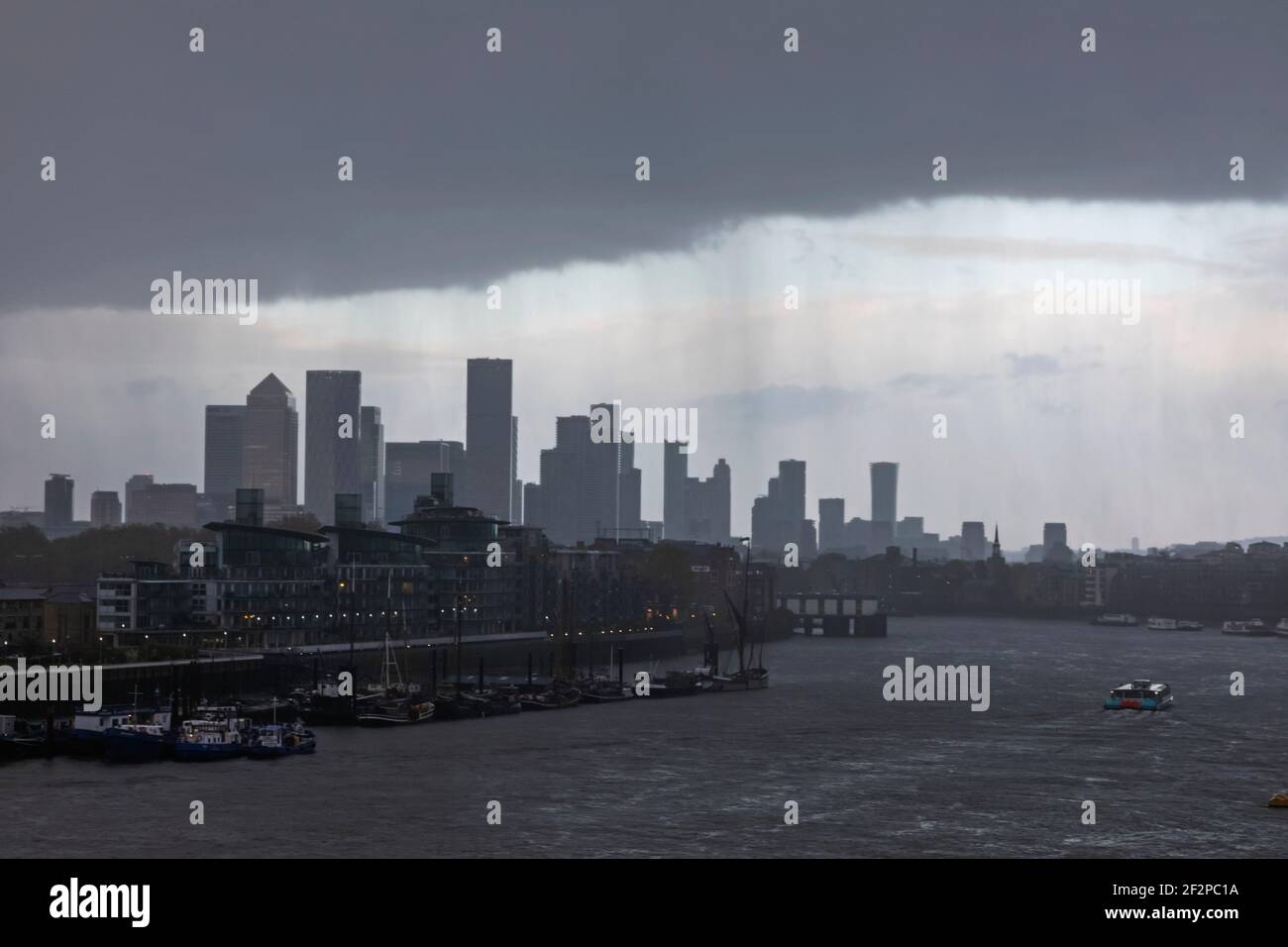England, London, Docklands, Themse und Canary Wharf Skyline an einem wolkigen nassen Tag Stockfoto