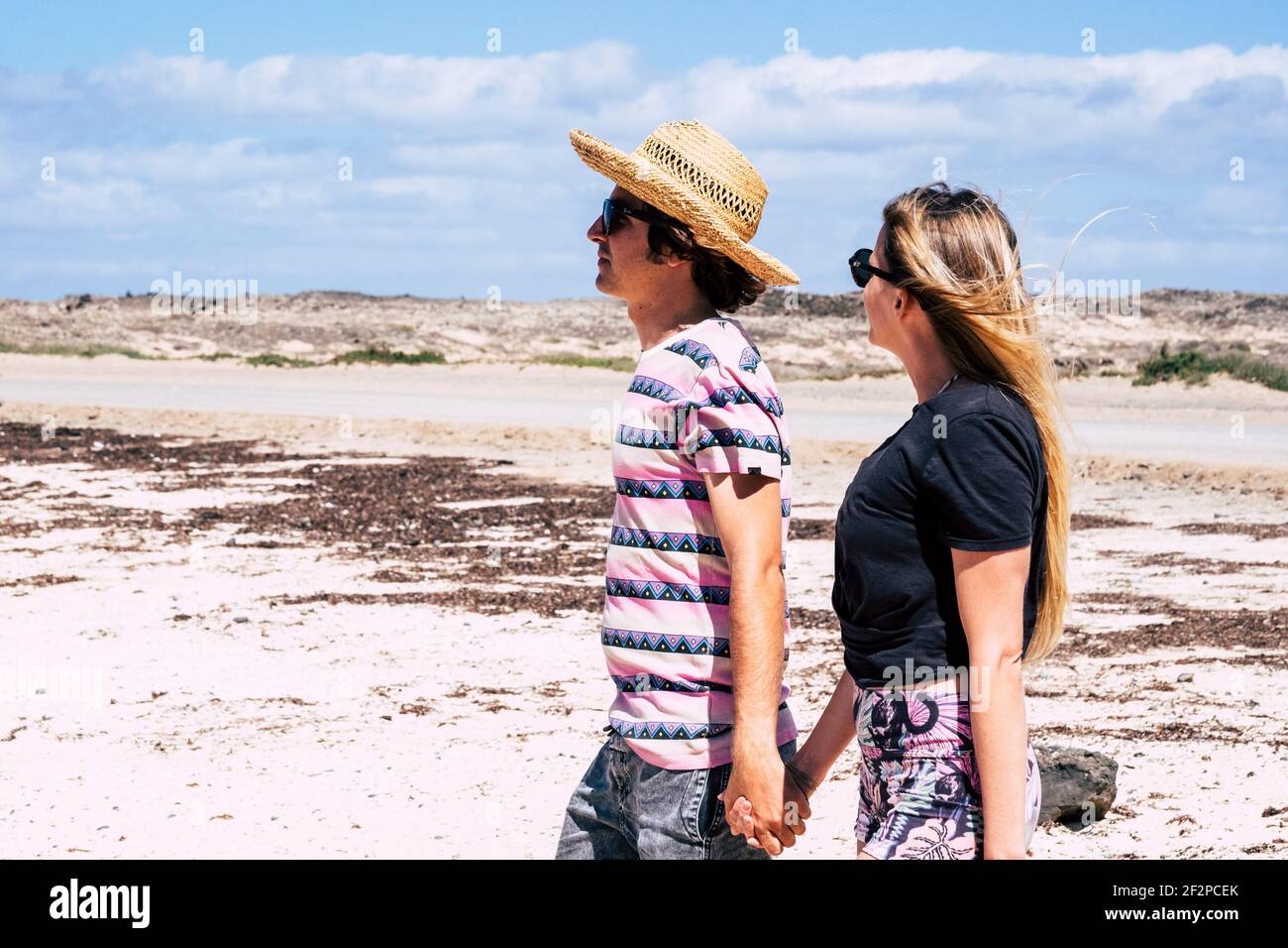 Junge Touristen Paar gehen Hand zusammen in der Liebe und halten Beziehung am Strand mit blauem Himmel in backgorund - Konzept der Reise-und Sommerurlaub Menschen Stockfoto