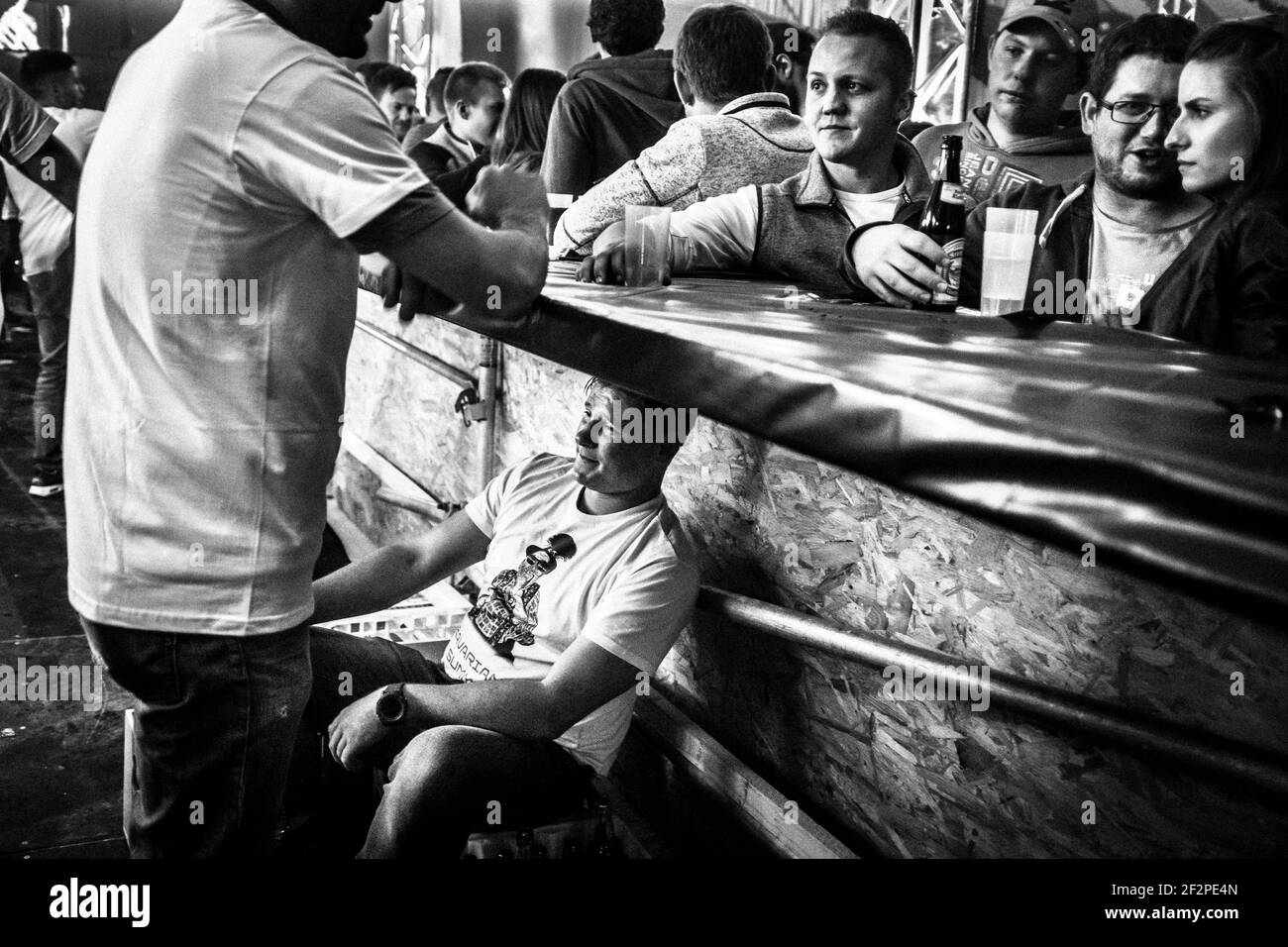 Deutschland, Bayern, Antdorf, Festwoche des Trachtenvereins. Mann, der während der Party im Festzelt unter der Bar sitzt. Stockfoto