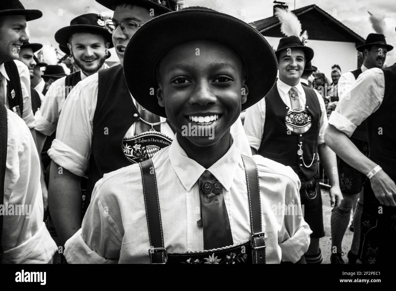 Deutschland, Bayern, Antdorf, Festwoche des Trachtenvereins. Lachender farbiger Junge eines traditionellen Kostümblubs. Stockfoto