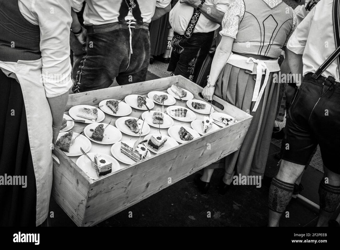 Deutschland, Bayern, Antdorf, Festwoche des Trachtenvereins. Frauen tragen eine Schachtel Kuchen zu den Gästen im Festzelt. Stockfoto