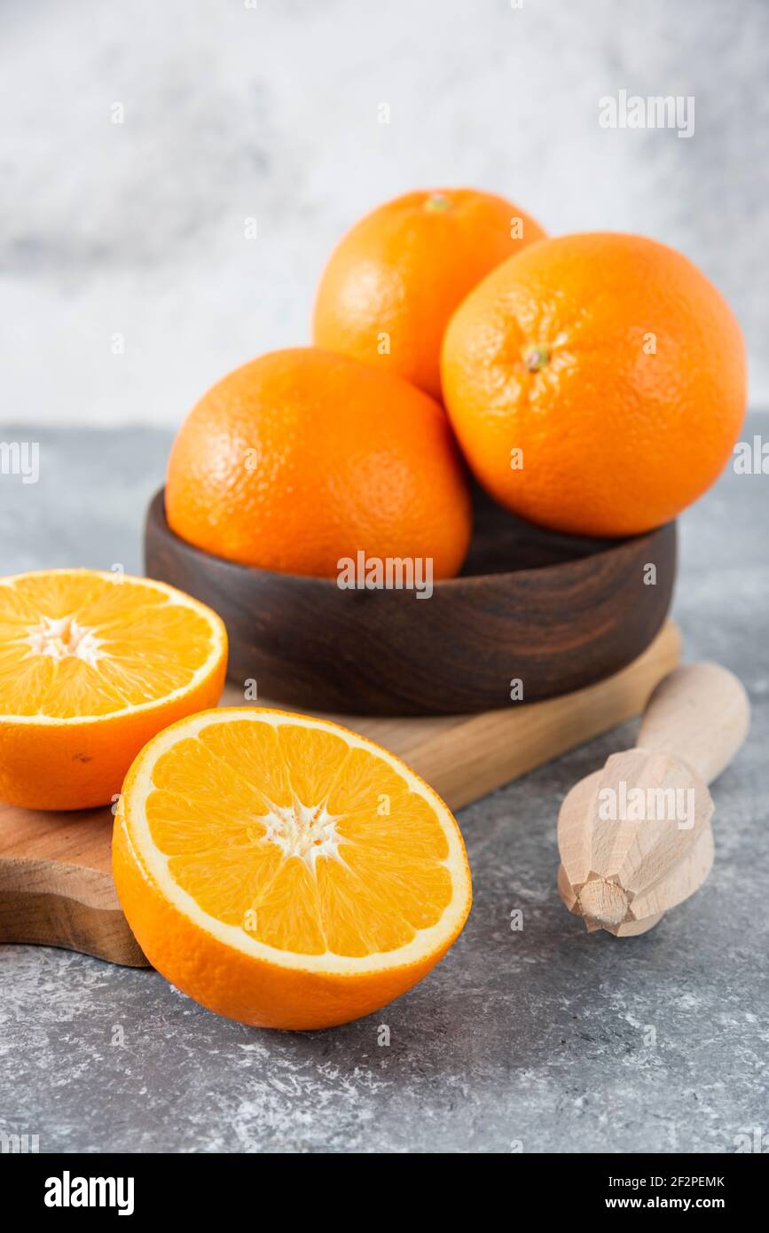 Ein Holzbrett voller saftiger Scheiben Orangenfrucht Auf steinernem Hintergrund Stockfoto