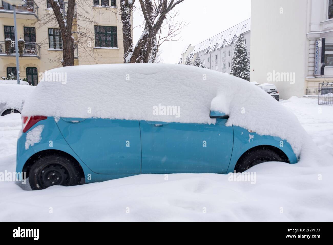 Auto unter Plane auf schneebedeckten Straßenrand im Winter, Deutschland  Stockfotografie - Alamy