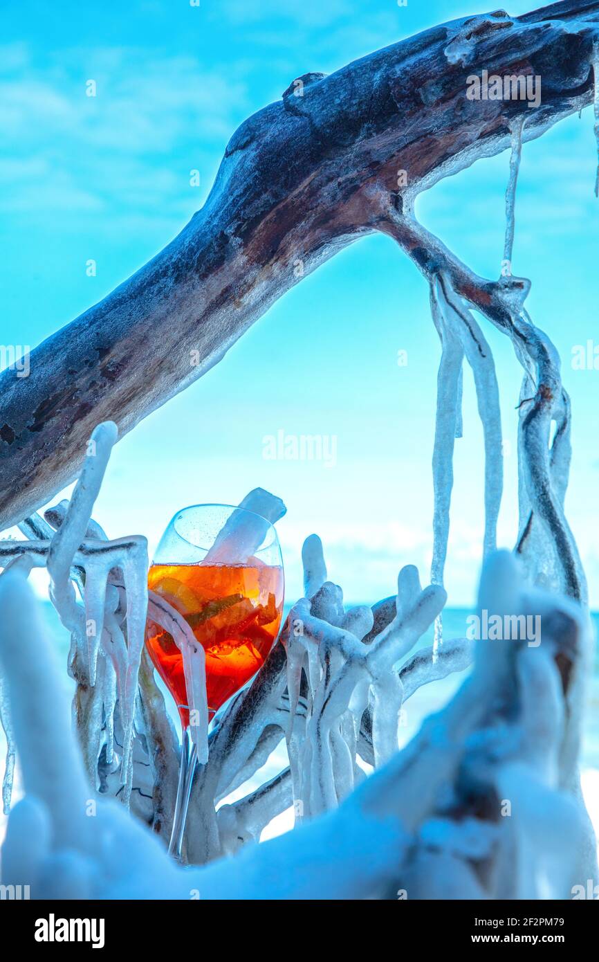 Aperol Spritz oder Sprizz ist ein gemischtes Getränk mit Weißwein und Mineralwasser und Zitrusfrüchten. Das Getränk wird am eisigen Ostseestrand serviert. Stockfoto