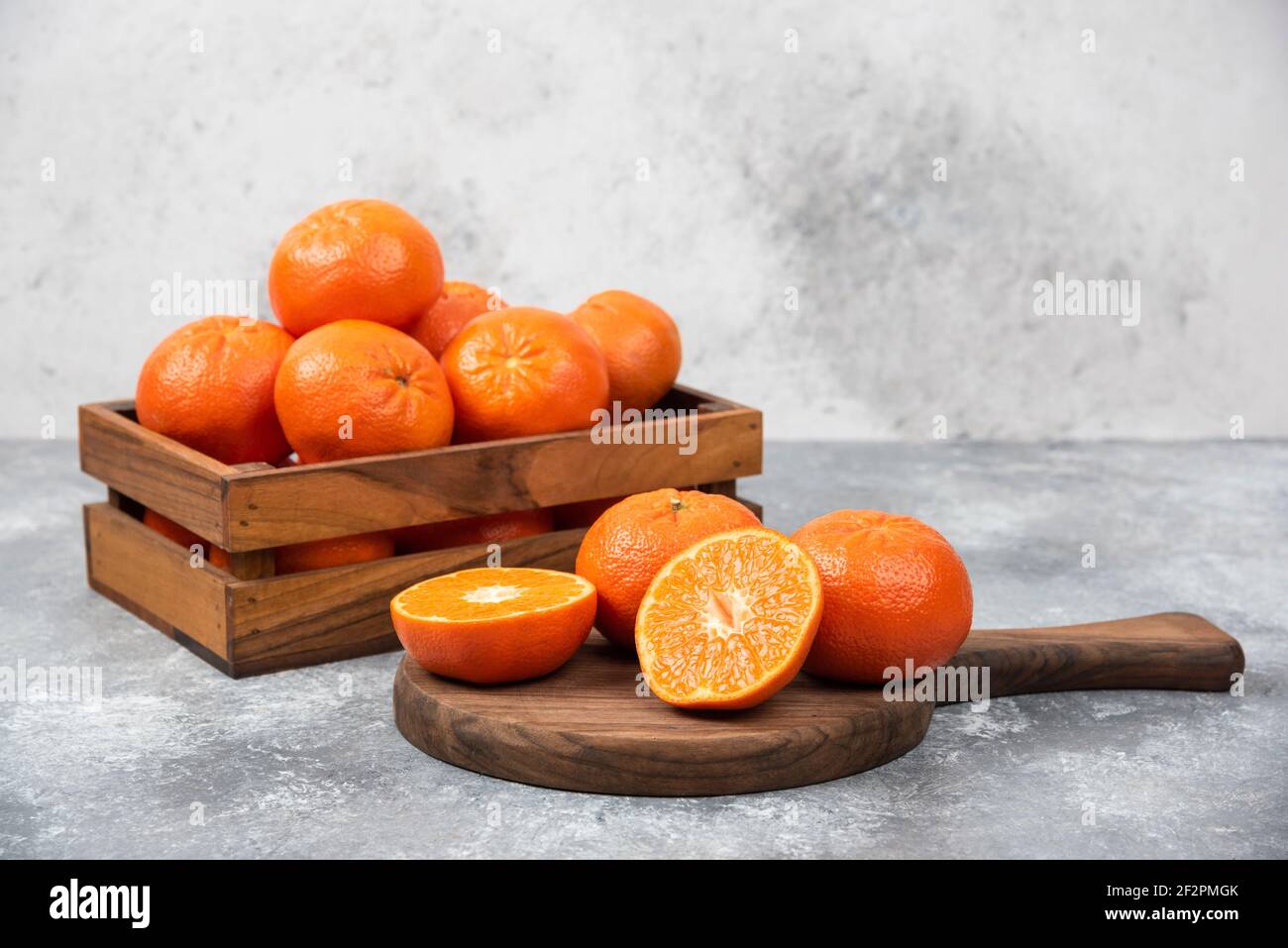 Ein Holzbrett aus saftigen Scheiben von Orangenfrüchten Steinhintergrund Stockfoto