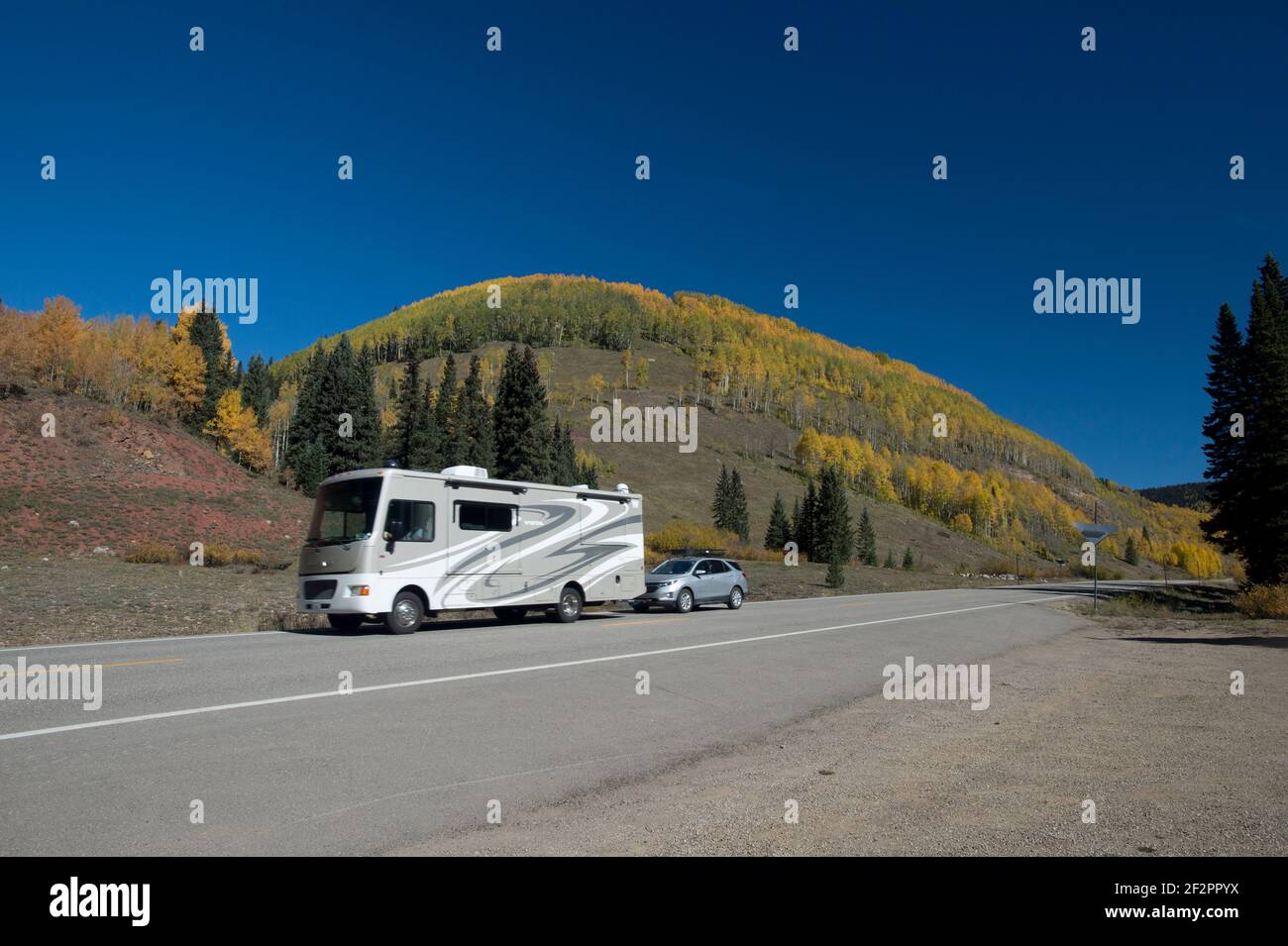 Wohnwagenschlepp mit kleinem Auto auf dem San Juan Skyway (Colorado State Route 145) im Südwesten Colorados. Stockfoto