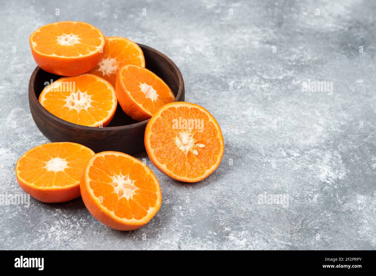 Saftige frische Orangenfrüchte in Scheiben geschnitten in einer Holzschüssel Stockfoto