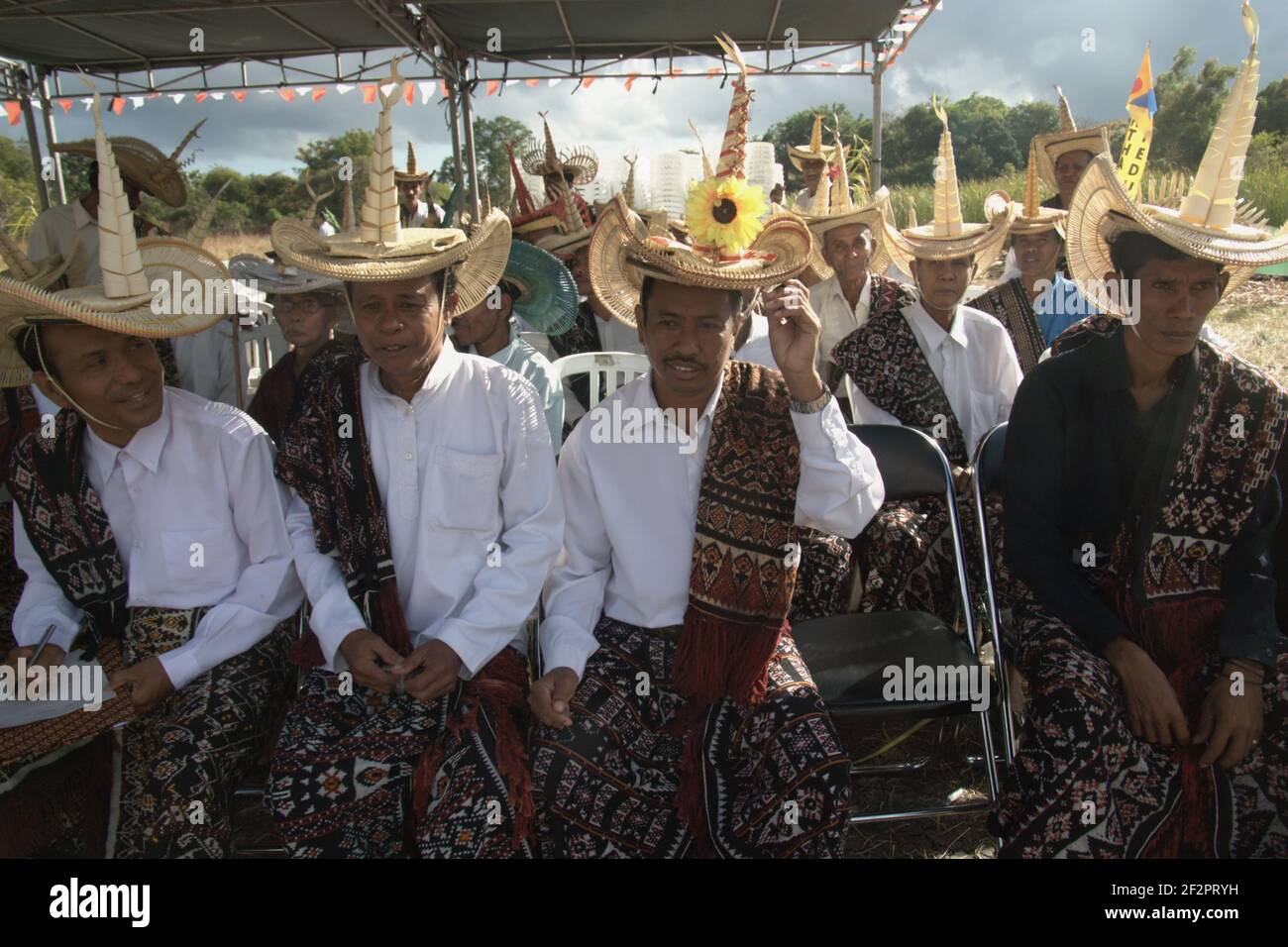 Eine Gruppe von Männern in traditioneller Kleidung, Vertreter traditioneller Gemeinschaften und Clans, die auf die Zeit warten, um eine Probe eines Rituals durchzuführen, das einen Konsens symbolisiert, um die endemische Schlangenhalsschildkröte (Chelodina mccordi) der Roten Insel vor dem Aussterben zu retten. Die Probe findet einige Stunden vor der eigentlichen Zeremonie im Dorf Maubesi, Rote Insel, Indonesien statt. Stockfoto