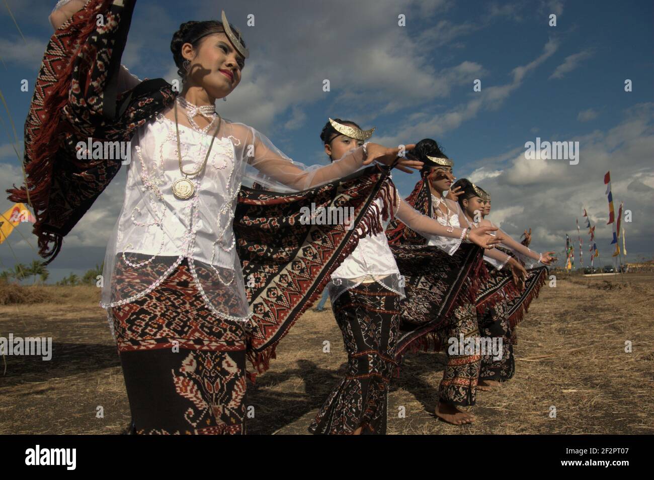 Junge Frauen tanzen in einer Probe vor einer zeremoniellen Veranstaltung, die von indonesischen Beamten besucht wird, die die endemische Schlangenhalsschildkröte (Chelodina mccordi) von Rote Island in einen der geeigneten Lebensräume im Peto-See, Maubesi-Dorf, Rote Insel, Indonesien, freilassen soll. Stockfoto