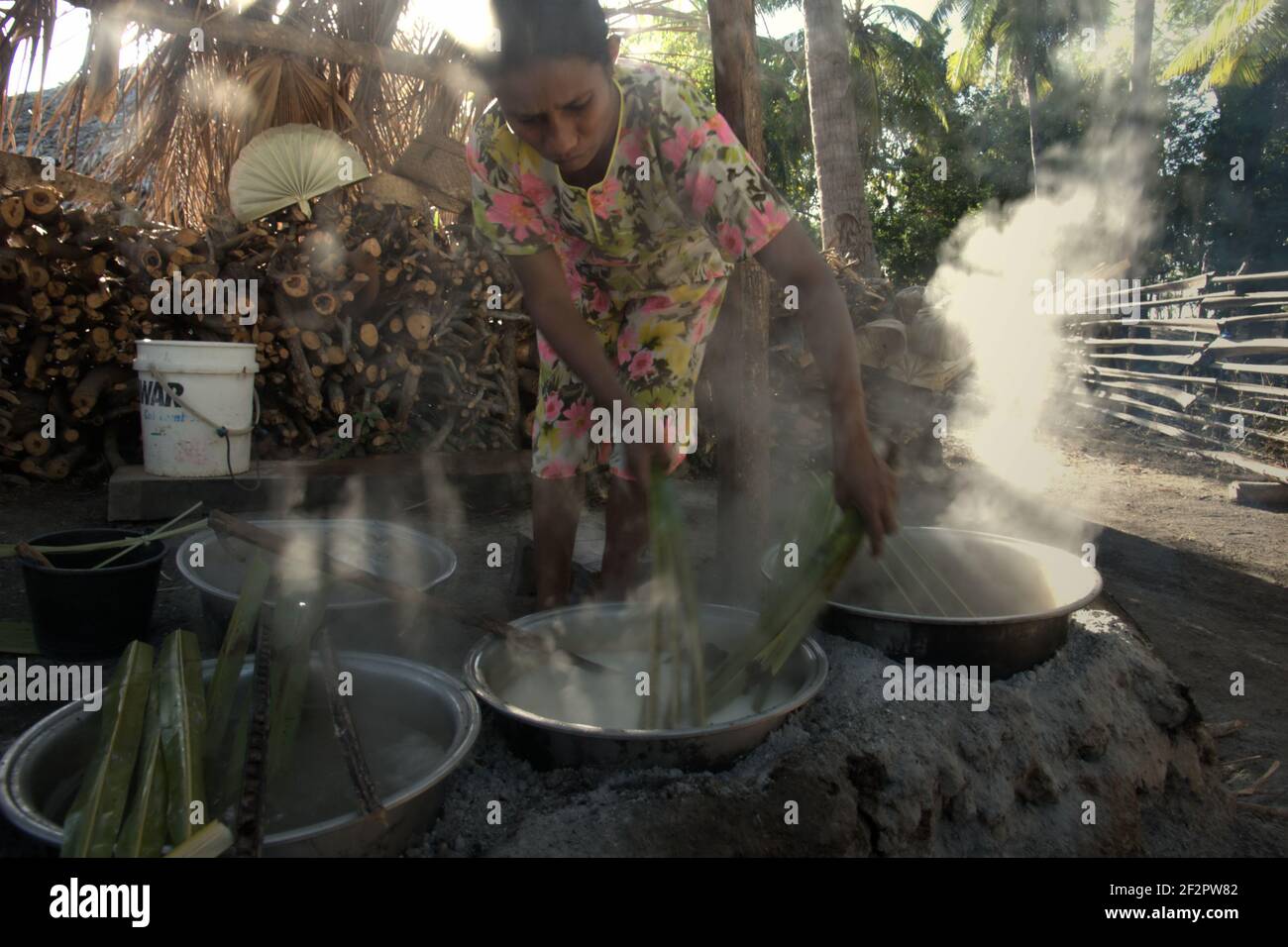 Yunce Unbanu kocht palmsaft, um Palmzucker im Dorf Oehandi, Rote Insel, Indonesien zu machen. Stockfoto