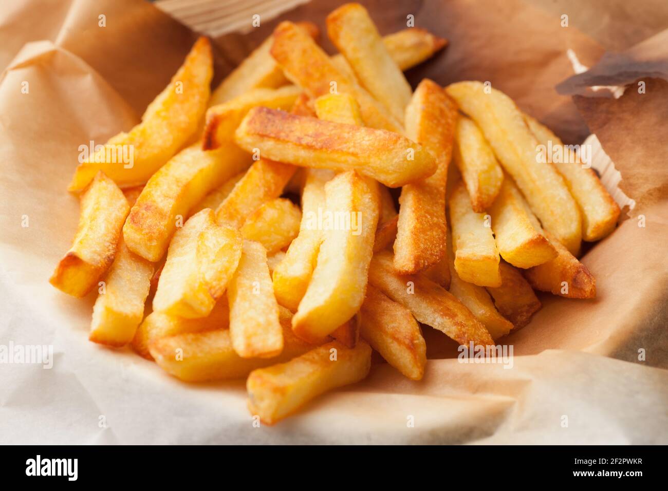 Hausgemachte Ofen gebackene pommes Frites auf Küchenpapier. Schnelle, ungesunde Lebensmittel. Stockfoto