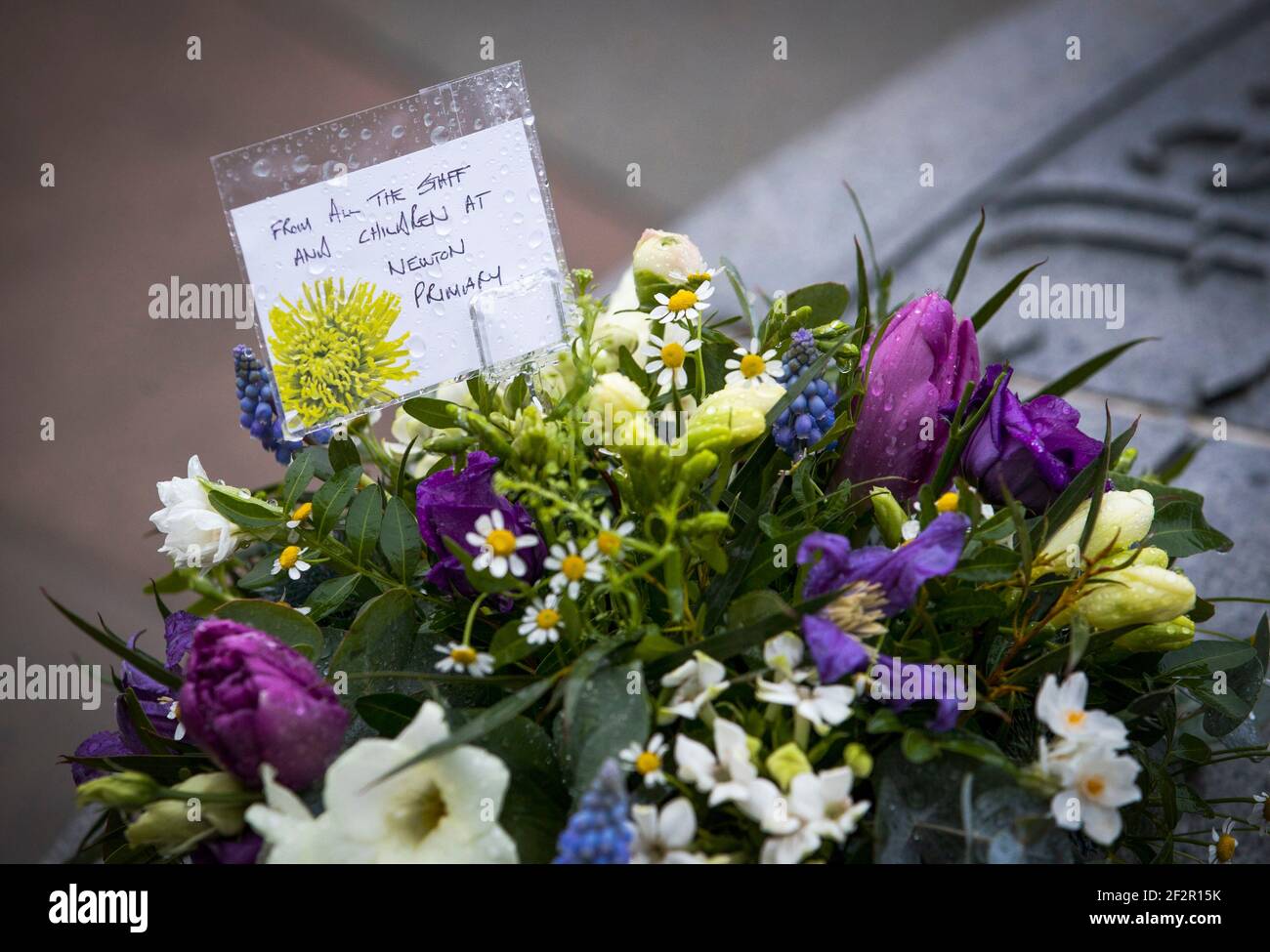 Blumengebete, die vor dem 25th. Jahrestag der Schießerei am Samstag im Gedenkbrunnen auf dem Friedhof von Dunblane für die Opfer des Massakers von Dunblane hinterlassen wurden. Bilddatum: Freitag, 12. März 2021. Stockfoto