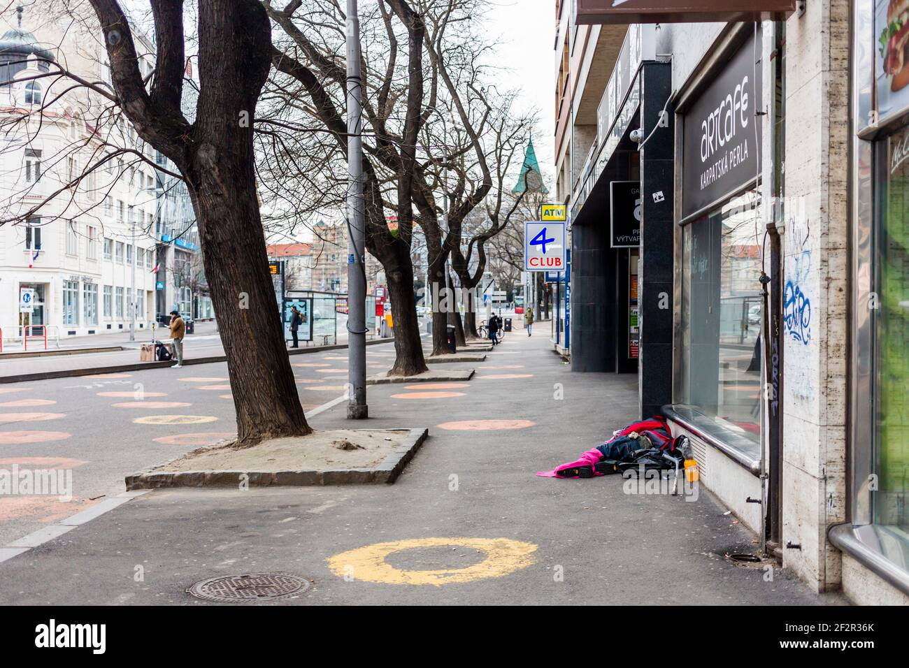 Obdachlose Person, die während der Sperre im März 2020 auf dem Boden auf einem Platz lag und keinen Platz zum Abschalten hatte. Stockfoto