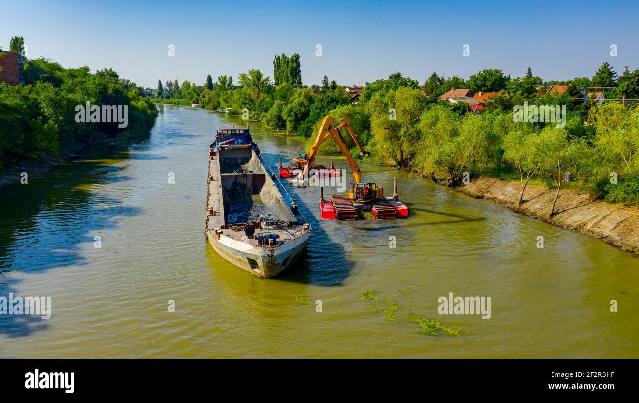 Oben auf zwei Bagger Bagger Baggern, wie sie Baggern, Arbeiten an Fluss, Kanal, Vertiefung und Entfernen von Sediment, Schlamm aus Flussbett in einem verschmutzten Wasser Stockfoto