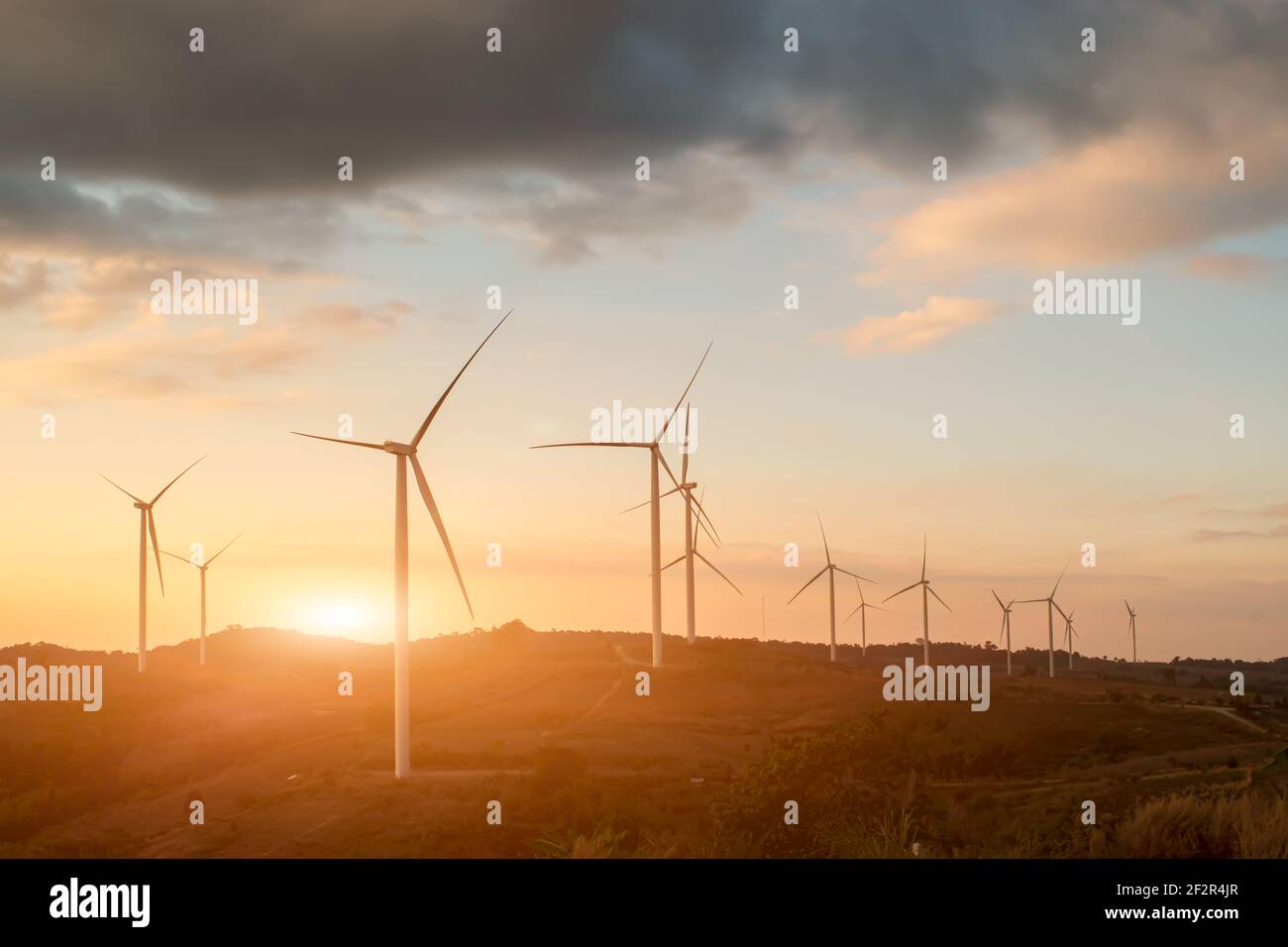 Silhouette von Windenergieanlagen. Schöne Sicht auf Windgeneratoren im Berghügel bei Sonnenuntergang. Stockfoto