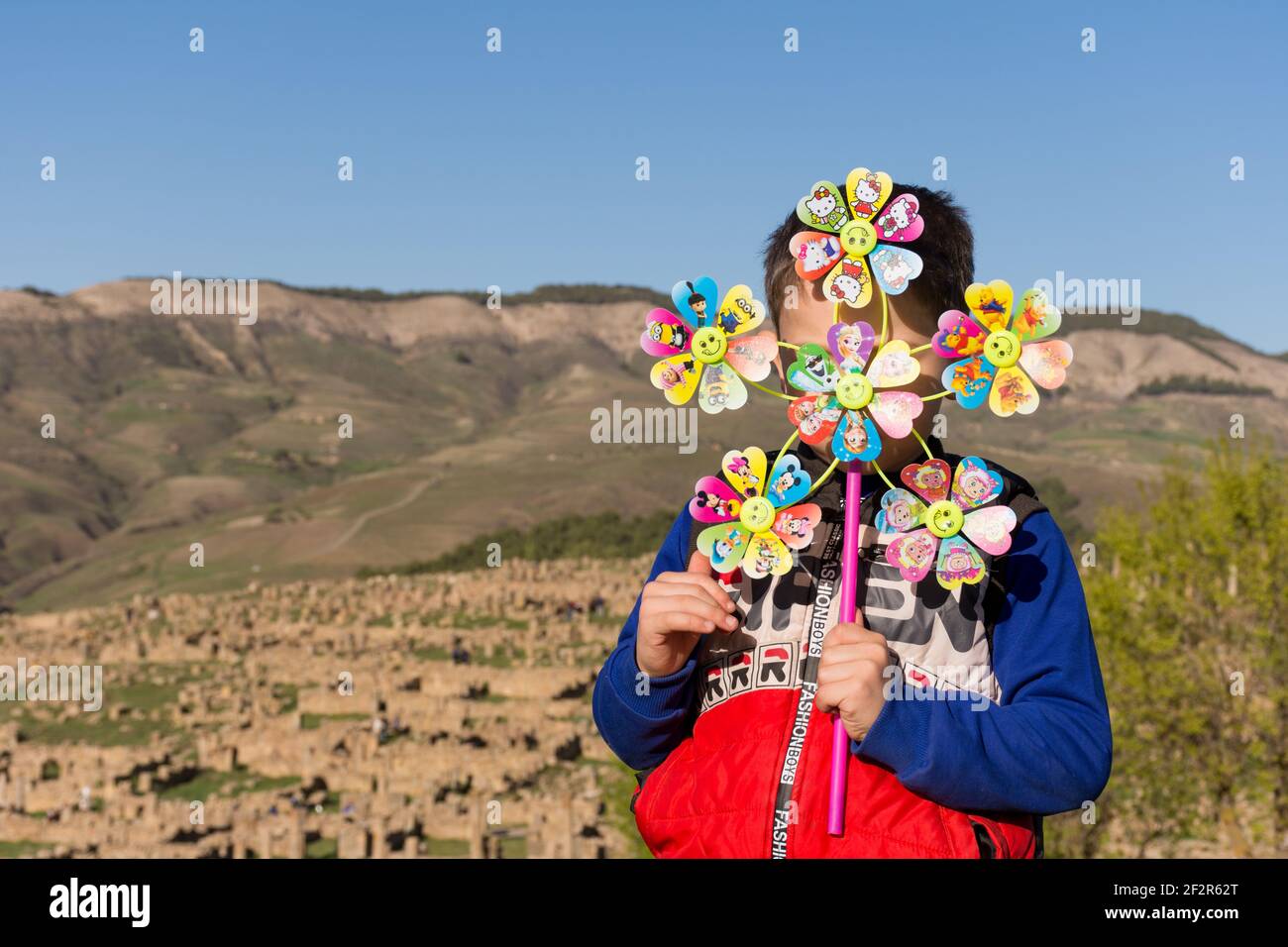 Vorderansicht eines Jungen mit einem bunten Windrad Spielzeug Stockfoto