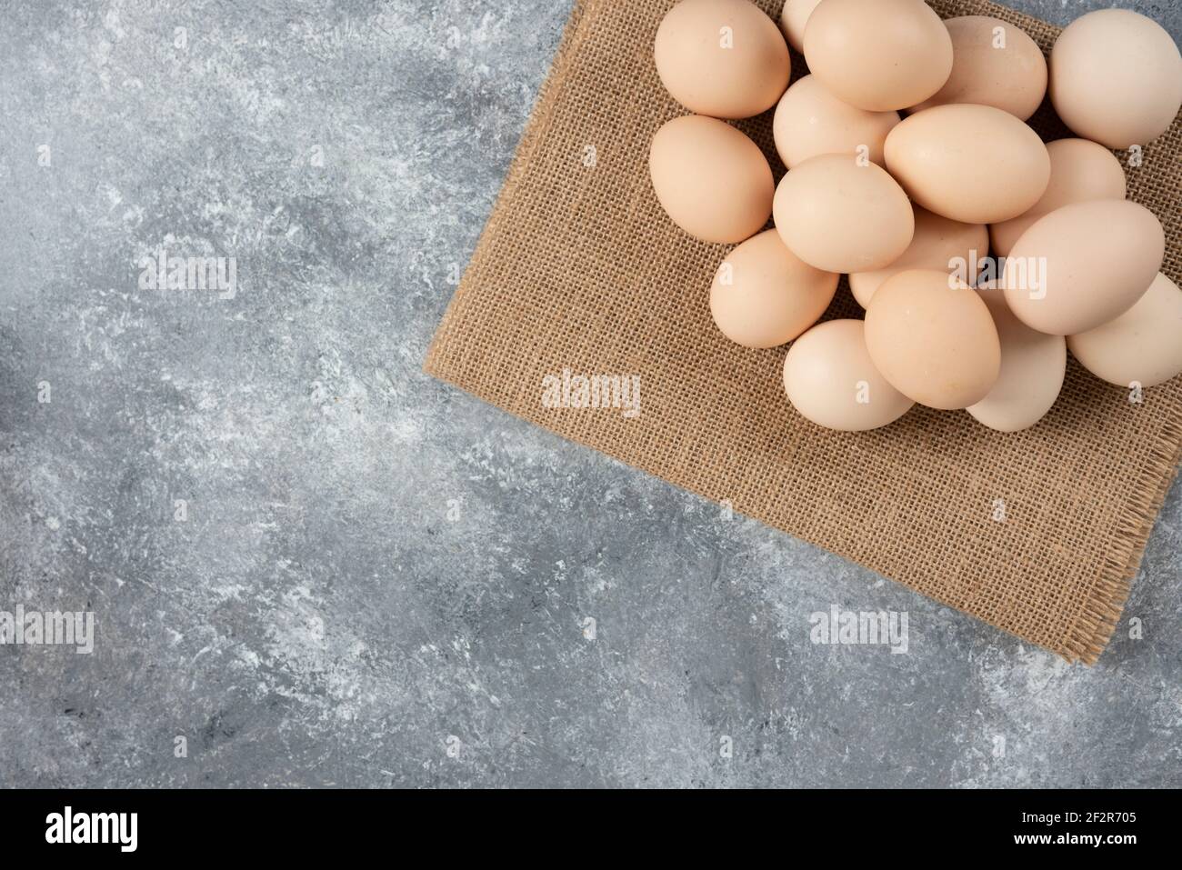 Stapel von Bio-ungekochten Eiern mit Tischdecke auf Marmoroberfläche Stockfoto