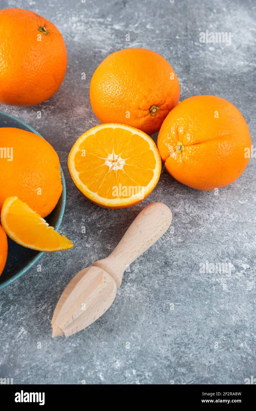Eine Schüssel voller geschnittener und voller saftiger Orangenfrüchte Mit Holzreimer Stockfoto