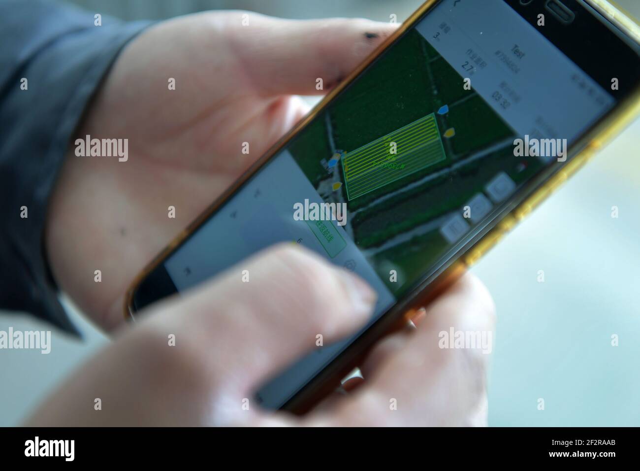 (210313) -- NANCHANG, 13. März 2021 (Xinhua) -- EIN Mitarbeiter überprüft das Gebiet der Ackerflächen, die in der ländlichen Kooperative Datian in der Stadt Jiangxiang, Landkreis Nanchang, Provinz Jiangxi in Ostchina, ausgesät werden sollen, 12. März 2021. Die Bauernhöfe der Landgenossenschaft Datian begrüßten am Freitag einen "intelligenten" Frühjahrsplug, bei dem unbemannte Technologien neue Lösungen der modernen Landwirtschaft boten. Durch die Nutzung dieser neuen Technologien können die Betriebe mit einer Gesamtfläche von 10.000 mu (ca. 666,67 Hektar) von nur 26 Menschen regiert werden. (Xinhua/Peng Zhaozhi) Stockfoto