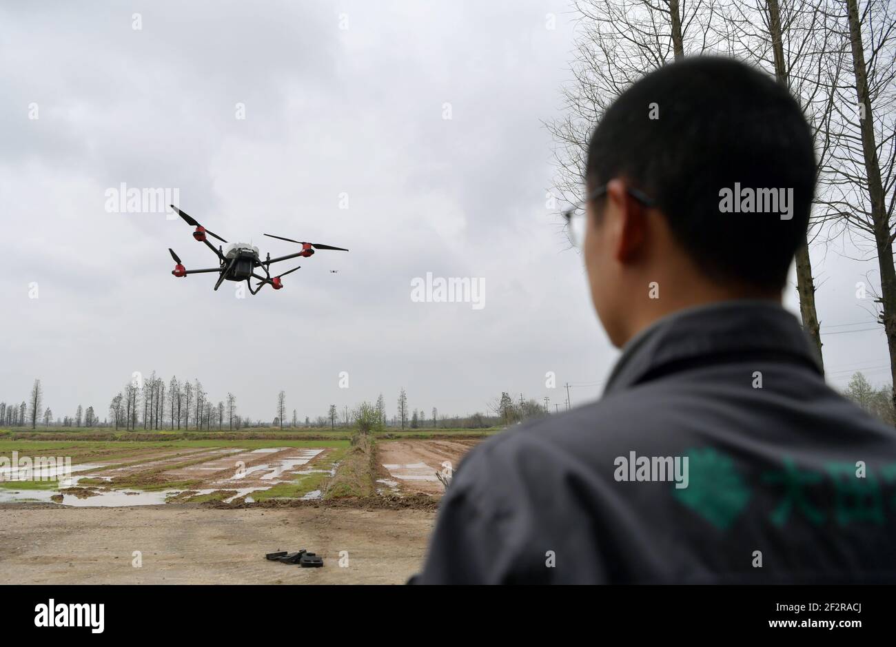 (210313) -- NANCHANG, 13. März 2021 (Xinhua) -- EIN Mitarbeiter betreibt eine unbemannte Aussaat-Maschine per Fernbedienung in der ländlichen Kooperative Datian in der Stadt Jiangxiang, Bezirk Nanchang in der Provinz Jiangxi in Ostchina, 12. März 2021. Die Bauernhöfe der Landgenossenschaft Datian begrüßten am Freitag einen "intelligenten" Frühjahrsplug, bei dem unbemannte Technologien neue Lösungen der modernen Landwirtschaft boten. Durch die Nutzung dieser neuen Technologien können die Betriebe mit einer Gesamtfläche von 10.000 mu (ca. 666,67 Hektar) von nur 26 Menschen regiert werden. (Xinhua/Peng Zhaozhi) Stockfoto