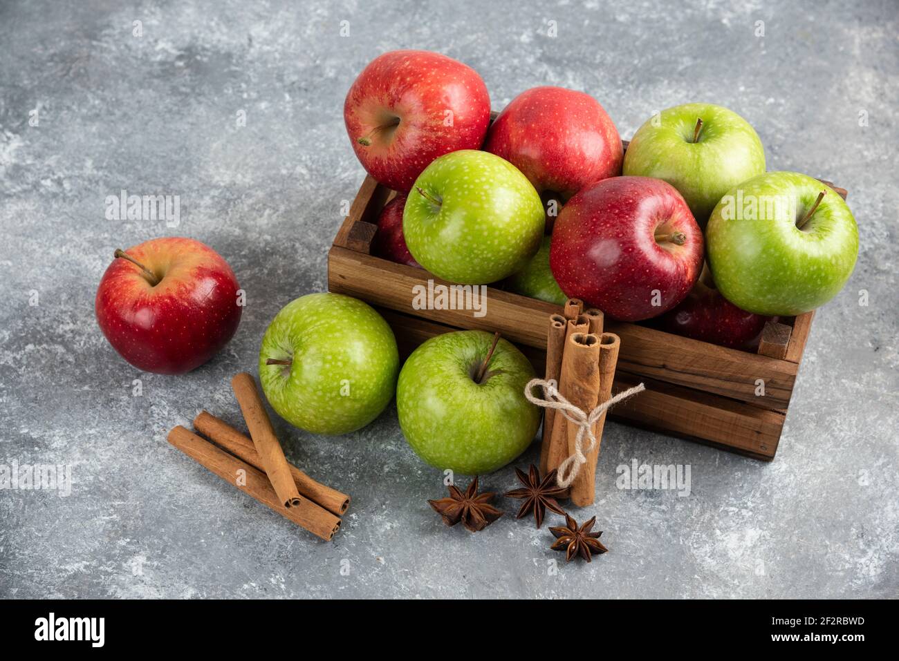 Ganze leckere grüne und rote Äpfel in Holzkiste Stockfoto