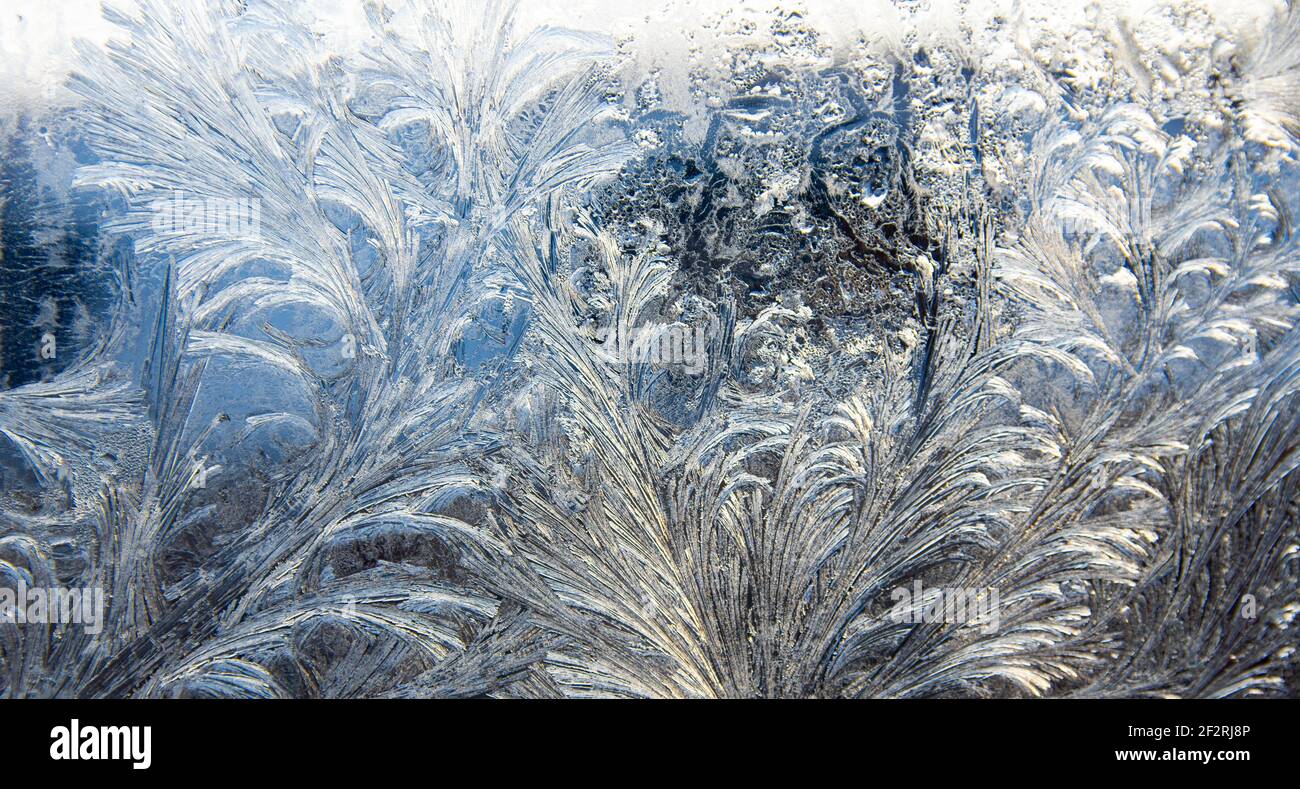 Frostmuster auf einem Fensterglas im Winter (Als abstrakter Winterhintergrund) Stockfoto