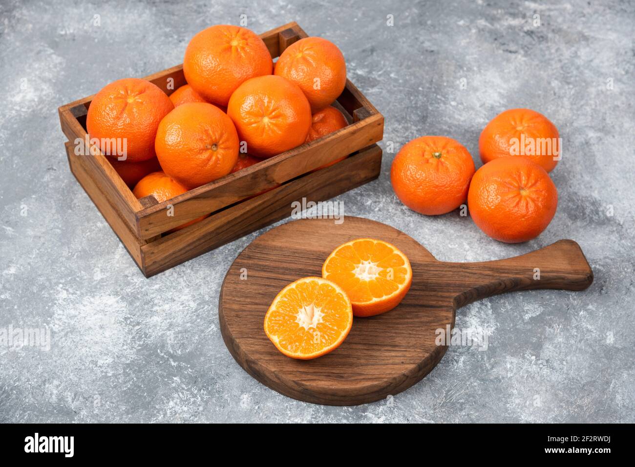 Ein Holzbrett aus saftigen Scheiben von Orangenfrüchten Steinhintergrund Stockfoto