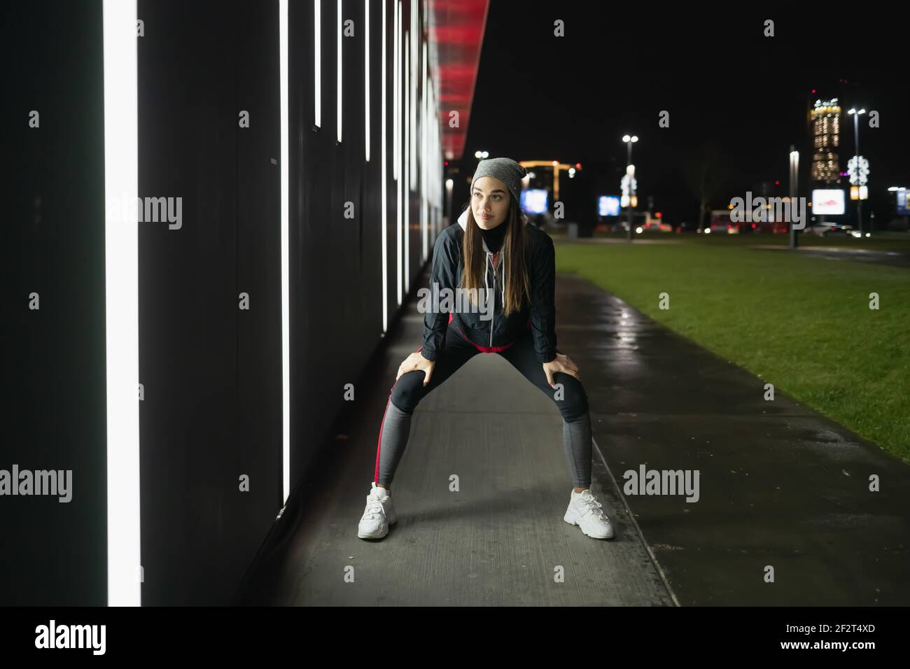 Die lächelnde während bereitet sich auf eine Nacht laufen um die Stadt Stockfoto