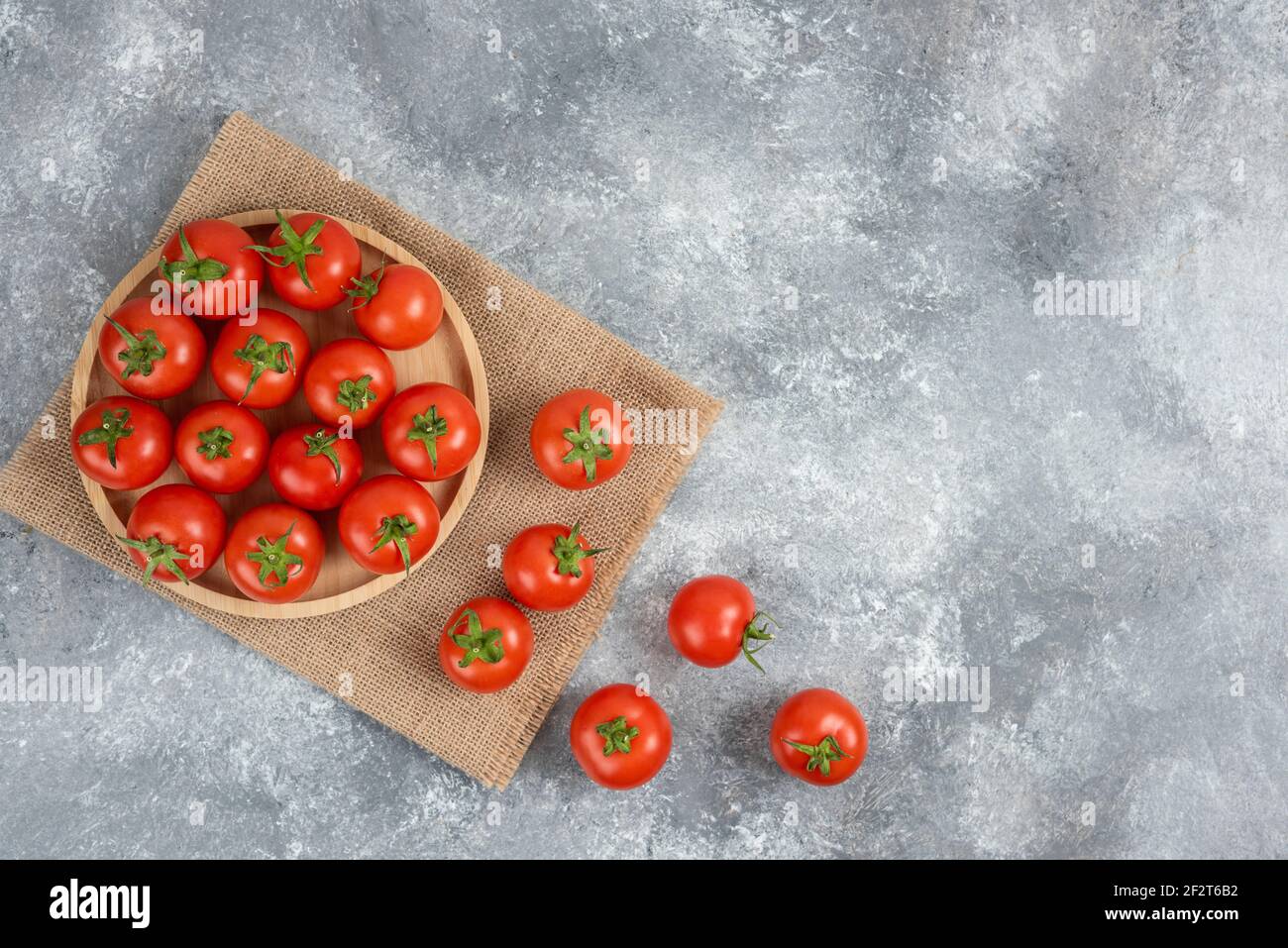 Holzplatte mit frischen Bio-Tomaten auf Marmor Hintergrund Stockfoto