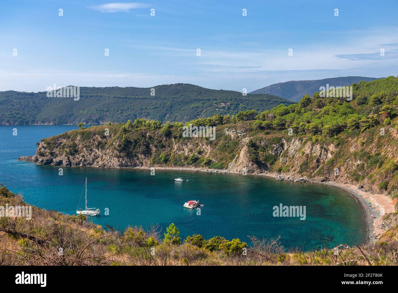 Schöne Meereslandschaft an einem kleinen wilden Strand der Insel Elba in der smaragdgrünen Lagune mit Segelboot. Toskana, Italien. Stockfoto
