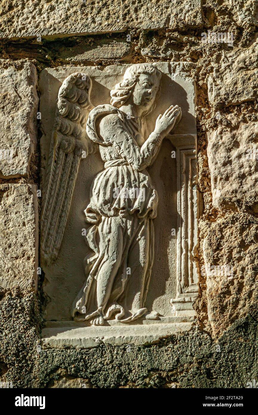 Bas-Relief eines reich gekleideten betenden Engels, eingefügt in eine Wand eines Hauses. Castiglione a Castauria, Provinz Pescara, Abruzzen, Italien, Europa Stockfoto