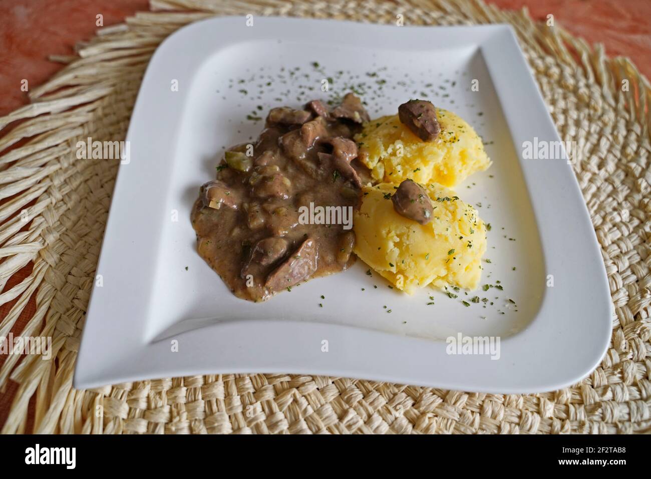 Kartoffelpüree mit Nierenkreuzragout auf weißem Teller Stockfoto