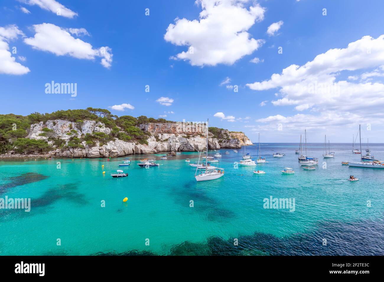 Blick auf die schönste Bucht Cala Macarella der Insel Menorca mit smaragdgrünem Wasser und vielen Yachten am Meer. Balearen, Spanien Stockfoto