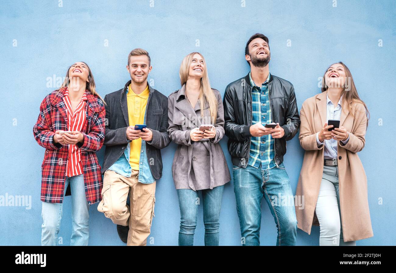 Glückliche Freunde Gruppe mit Smartphones gegen blaue Wand an der Universität college Break - Junge Menschen Spaß mit mobilen smart Telefon Stockfoto