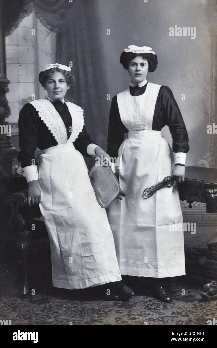 Ganzkörperportrait von zwei Dienstmädchen, Hausmädchen, viktorianischen Dienstmädchen oder edwardianischen Dienstmädchen in Schürzen & Dienstmädchen Uniformen Rhyl Wales UK c1900-1920 Stockfoto