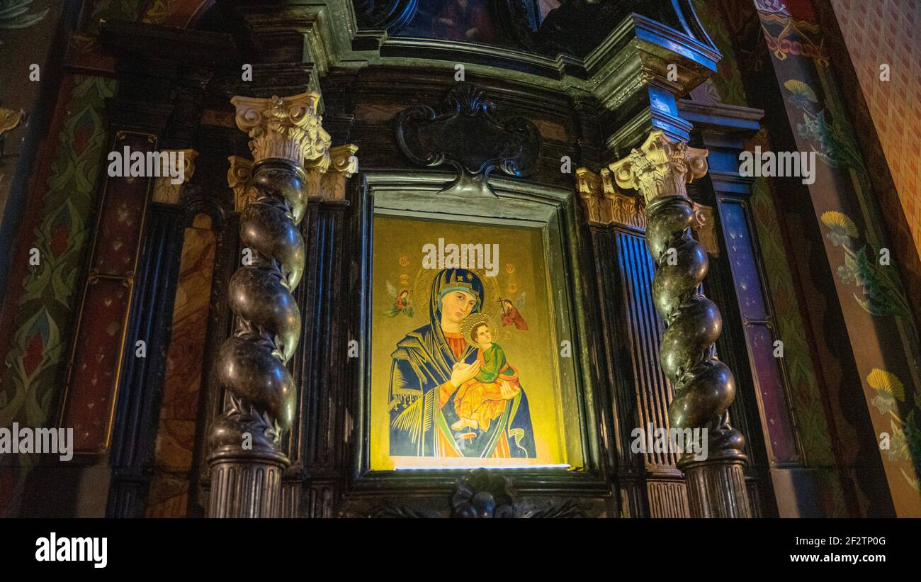 Die Jungfrau Maria und das Kind, oder Mutter Maria und Kind Jesus Kunstwerk in wirbelnden hölzernen Jugendstilsäulen eingerahmt, von unten beleuchtet, in Krakau, Polen Stockfoto