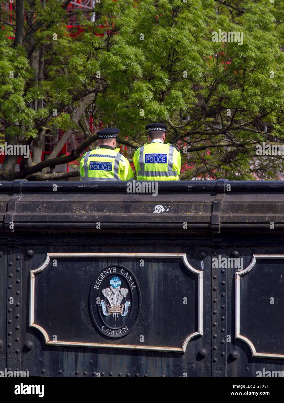 Zwei Metropolitan-Polizisten in Hi-viz-Jacken, die auf einer Brücke über den Regents Canal, Camden, London, Großbritannien, mit Kopierraum stehen Stockfoto