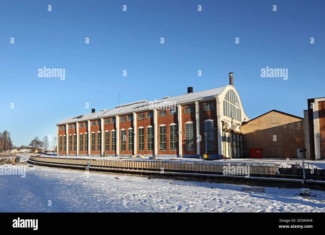 MOTALA, SCHWEDEN- 13. FEBRUAR 2021: Viele waren während des schönen Winterwetters am Samstag auf dem Eis. Alte Motala verkstad (Motala Werkstatt) neben Göta Kanal. Stockfoto
