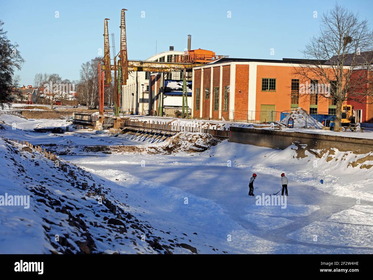 MOTALA, SCHWEDEN- 13. FEBRUAR 2021: Viele waren während des schönen Winterwetters am Samstag auf dem Eis. Alte Motala verkstad (Motala Werkstatt) neben Göta Kanal. Stockfoto