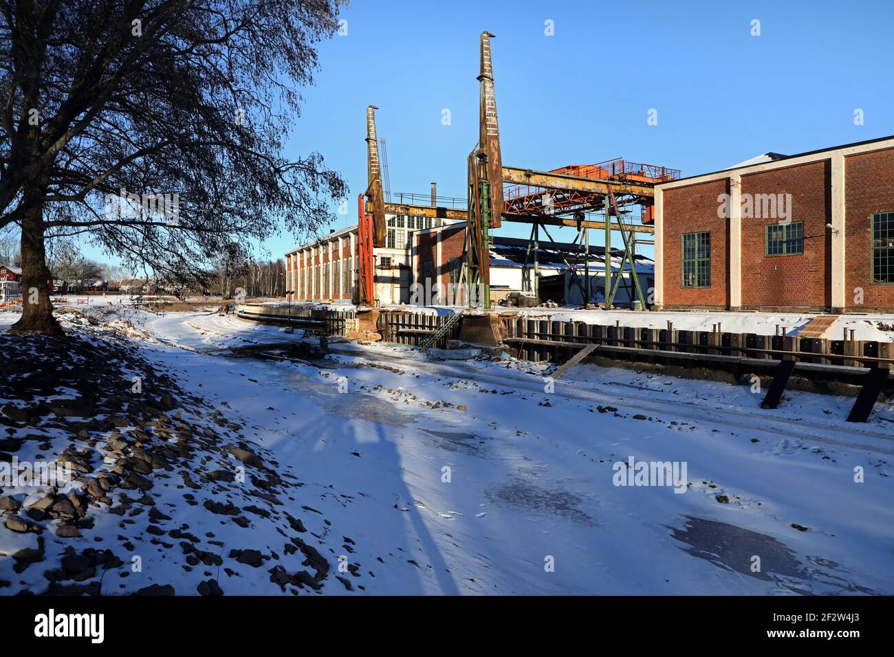 MOTALA, SCHWEDEN- 13. FEBRUAR 2021: Viele waren während des schönen Winterwetters am Samstag auf dem Eis. Alte Motala verkstad (Motala Werkstatt) neben Göta Kanal. Stockfoto