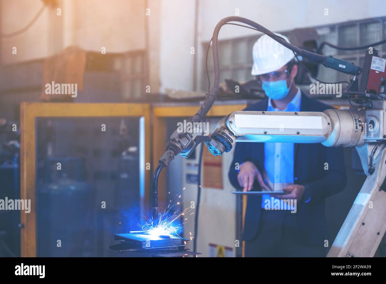 Ingenieur Kontrolle und Steuerung der Automatisierung Roboterarme Maschine in der intelligenten Fabrik Industrie auf Echtzeit-Monitoring-System-Software. Schweißrobotik A Stockfoto